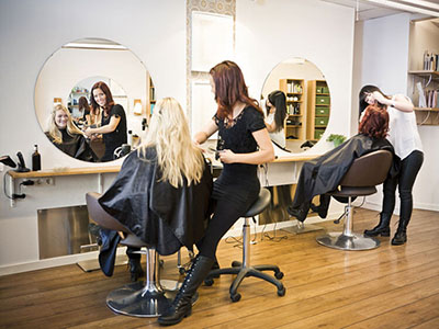 Gabinet fryzjerski chroniacy klientów przed koronawirusem dzięki ekranom ochronnym pomiędzy fotelami